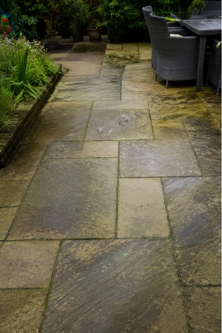 Indian sandstone patio darkened with algae and organic staining before restoration in Clitheroe